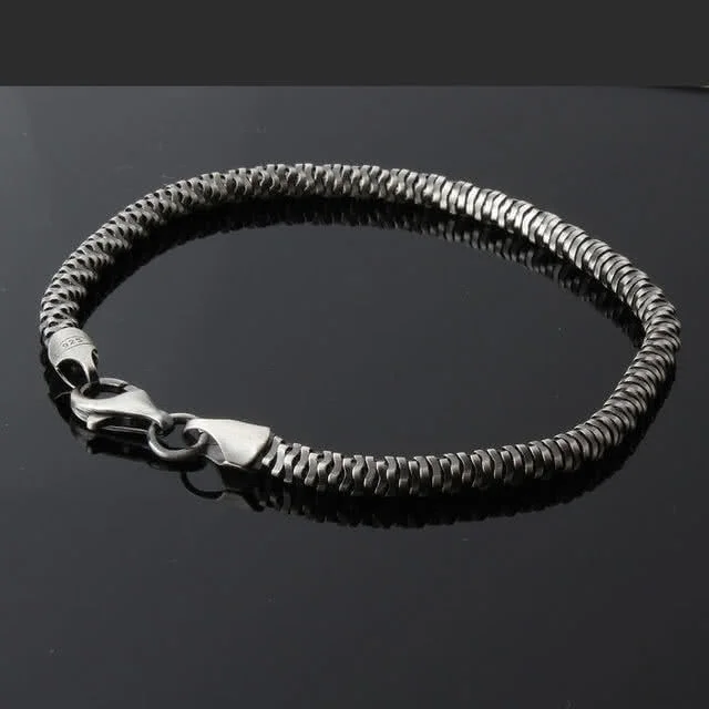 Contemporary design bracelet is created from over one hundred small silver discs